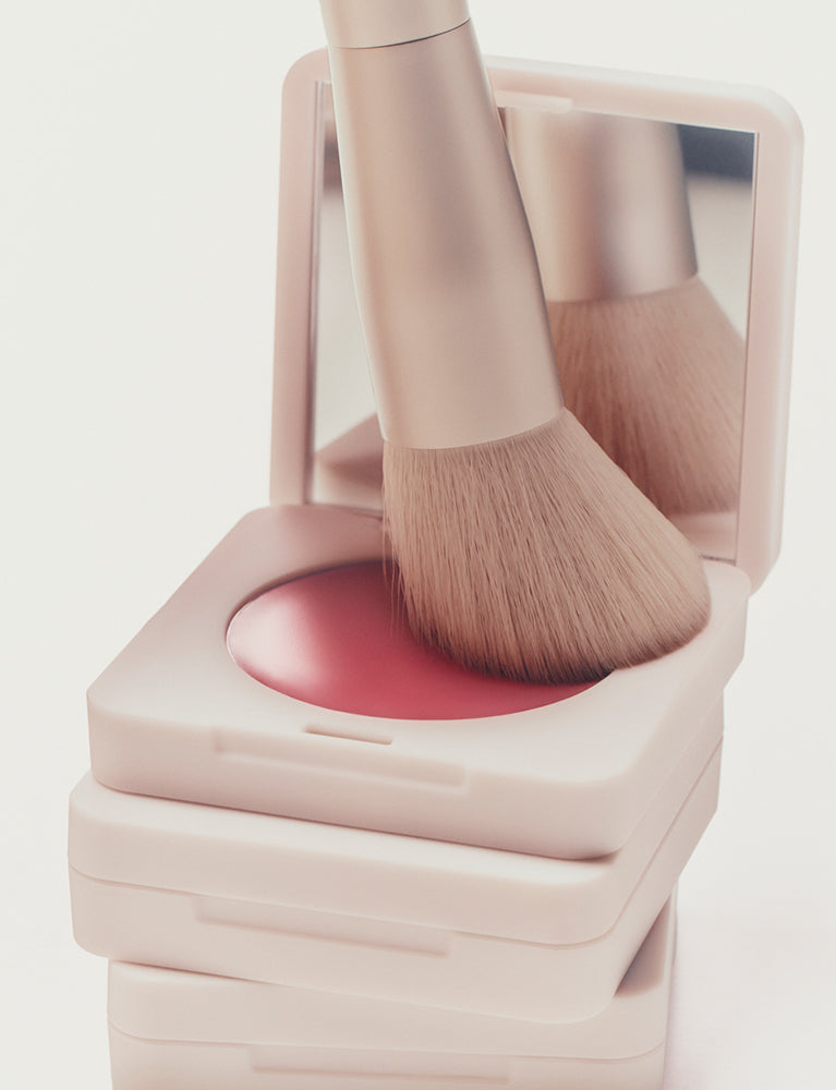 Blush brush being pressed into cream blush