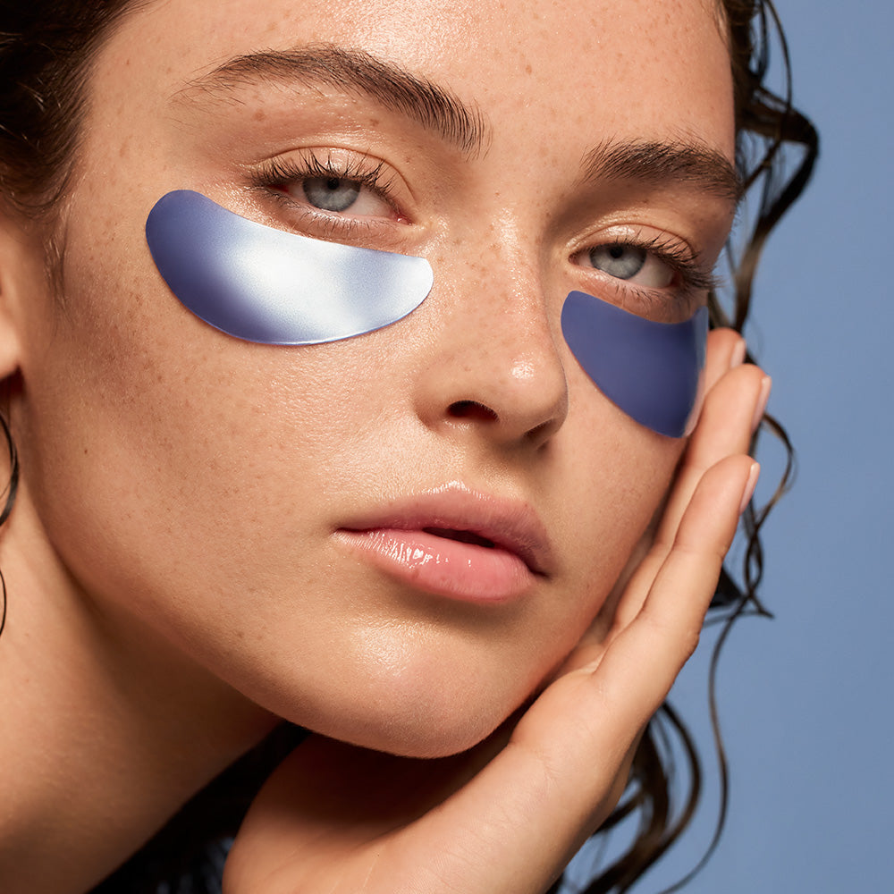 Woman with blue eye patches on a blue background
